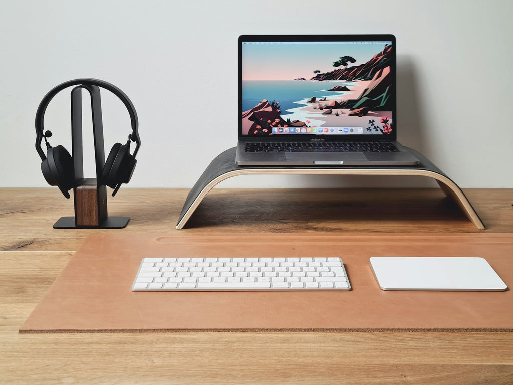 Wooden laptop stand holding a laptop, three-quarter view